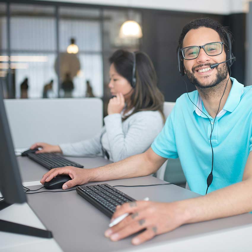 Man smiling using computer and headset